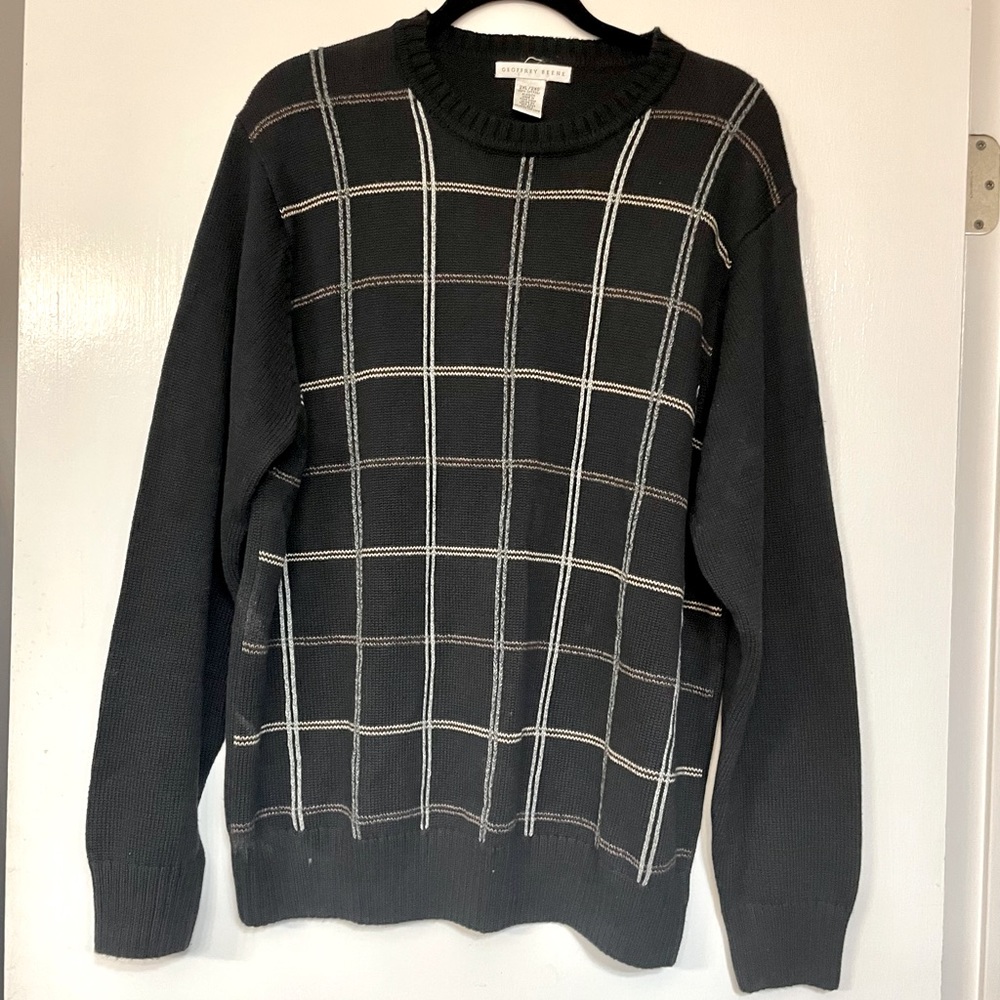 Black sweater with gray, beige, and taupe lines to form checks.